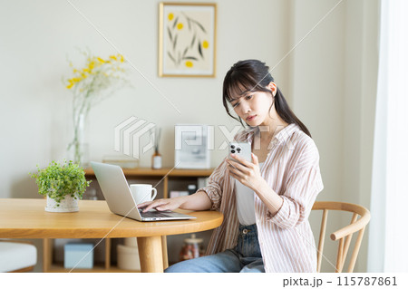 パソコンとスマホに悩む若い女性 115787861