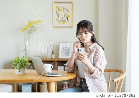 パソコンとスマホに悩む若い女性 115787862