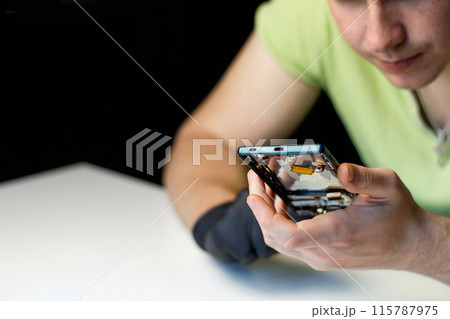 Man repair phone. Close up. Phone repair service, technical assistance, device maintenance, customer service. Electronics maintenance, repair shop advertisement Man repair phone. Close up. Phone repair service, technical assistance, device maintenance, customer service. Electronics maintenance, repair shop advertisement 115787975