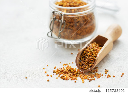 Healthy bee pollen grains. Bee pollen on a wooden spoon and glass jar. Healthy bee pollen grains. Bee pollen on a wooden spoon and glass jar. 115788401