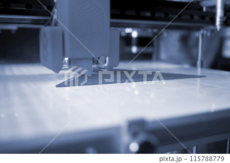 3D printer close up. A working 3D printer in process of printing object from molten plastic. 3D printer creating model by flowing liquid plastic from an extruder of printer. 3D printing technology 115788779