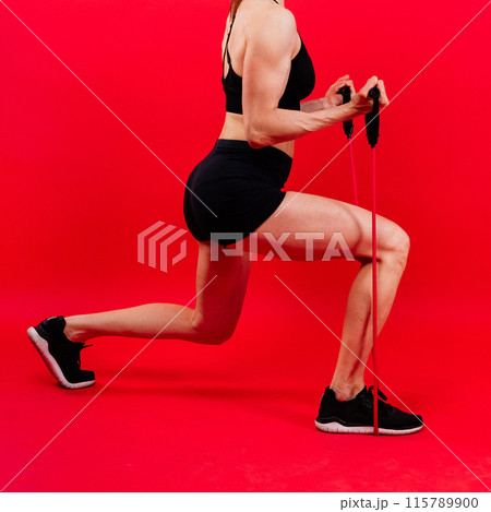 Athletic female performs exercises using a resistance band. Strength and motivation 115789900