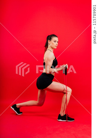 Athletic female performs exercises using a resistance band. Strength and motivation 115789901