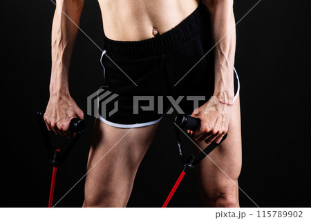 Athletic female performs exercises using a resistance band. Strength and motivation 115789902