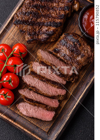 Fresh juicy delicious beef steak on a dark background 115790852