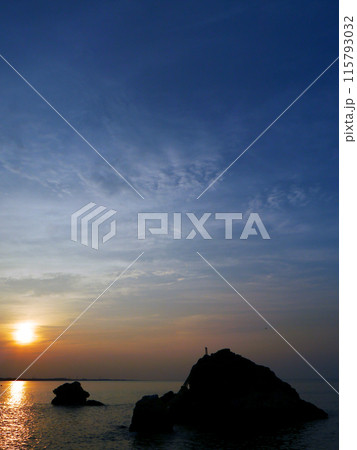 海に沈む夕日と岩のシルエット 115793032