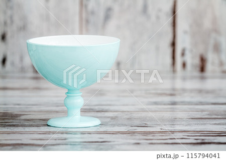 Single Turquoise Ice Cream Bowl on a White Wooden Background, Aesthetic Serveware with Copy Space 115794041