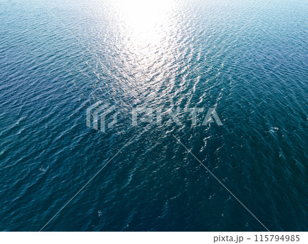 Aerial view of a blue sea surface water texture background,Sun reflections over ocean, Aerial flying drone view Waves water surface texture on sunny tropical ocean in Phuket island Thailand 115794985