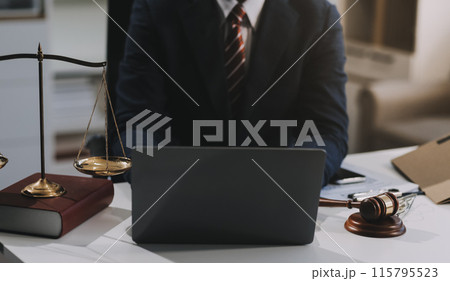 Male lawyer working with contract papers and wooden gavel on tabel in courtroom. justice and law ,attorney, court judge, concept. Male lawyer working with contract papers and wooden gavel on tabel in courtroom. justice and law ,attorney, court judge, concept. 115795523