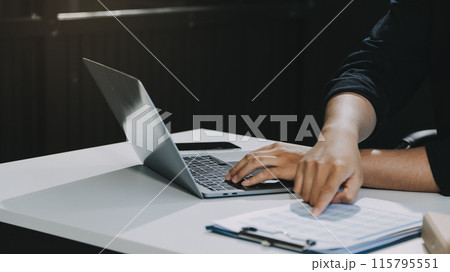 person using calculator calculating tax refund on the table 115795551