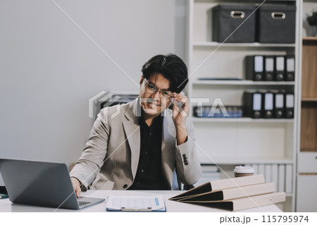 Video call online meeting asian businessman looking web camera and having fun talking and gesturing, man working inside office sharing plans with partners and colleagues, boss in shirt and glasses. 115795974
