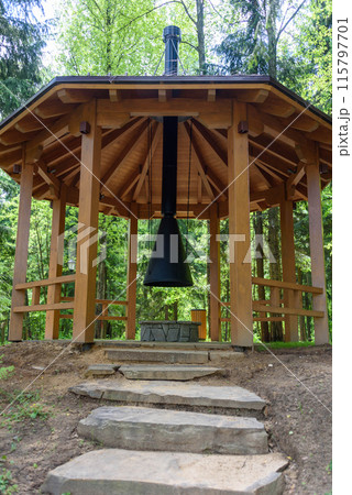 Stone steps lead to a wooden gazebo with a barbecue and a chimney. Stone steps lead to a wooden gazebo with a barbecue and a chimney. 115797701
