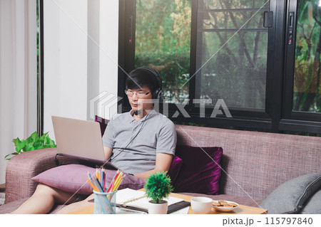 Businessman meeting online via video call on laptop in home office. Man wear headphone video calling or distance education e-leaning online course. 115797840