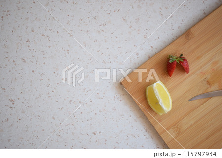 Lemon and strawberries cut on the kitchen counter 115797934