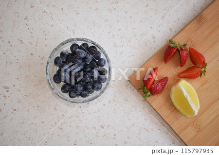 A glass bowl with frozen blueberries in white background 115797935