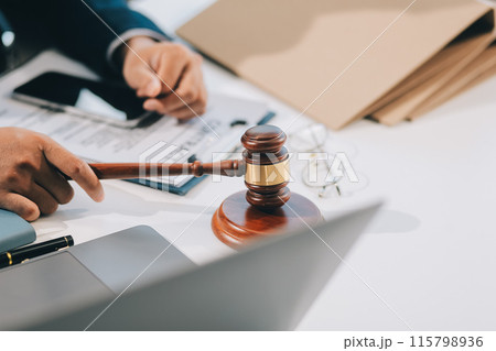 Male lawyer working with contract papers and wooden gavel on tabel in courtroom. justice and law ,attorney, court judge, concept. Male lawyer working with contract papers and wooden gavel on tabel in courtroom. justice and law ,attorney, court judge, concept. 115798936