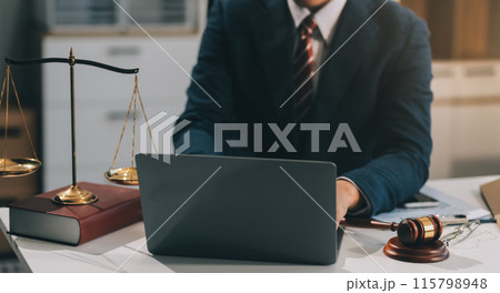 Male lawyer working with contract papers and wooden gavel on tabel in courtroom. justice and law ,attorney, court judge, concept. Male lawyer working with contract papers and wooden gavel on tabel in courtroom. justice and law ,attorney, court judge, concept. 115798948