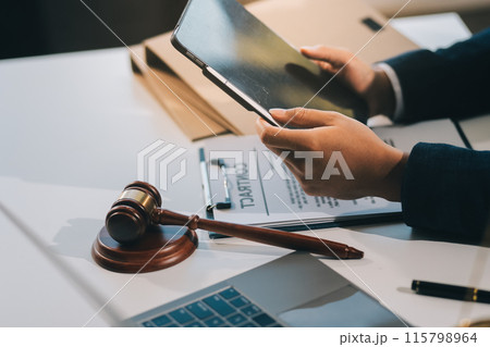 Male lawyer working with contract papers and wooden gavel on tabel in courtroom. justice and law ,attorney, court judge, concept. Male lawyer working with contract papers and wooden gavel on tabel in courtroom. justice and law ,attorney, court judge, concept. 115798964