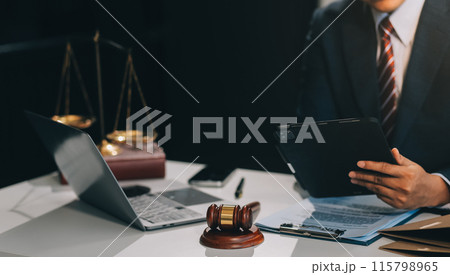 Male lawyer working with contract papers and wooden gavel on tabel in courtroom. justice and law ,attorney, court judge, concept. Male lawyer working with contract papers and wooden gavel on tabel in courtroom. justice and law ,attorney, court judge, concept. 115798965