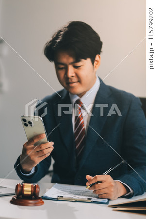 Male lawyer working with contract papers and wooden gavel on tabel in courtroom. justice and law ,attorney, court judge, concept. Male lawyer working with contract papers and wooden gavel on tabel in courtroom. justice and law ,attorney, court judge, concept. 115799202