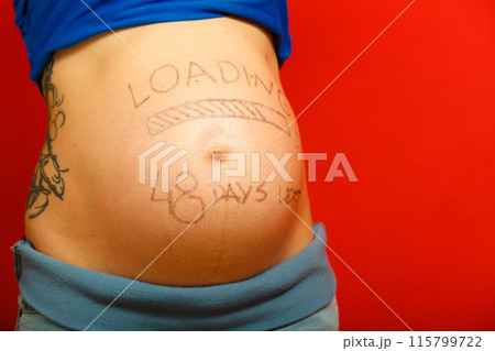 Pregnant woman with loading concept painted on her belly Pregnant woman with loading concept painted on her belly 115799722
