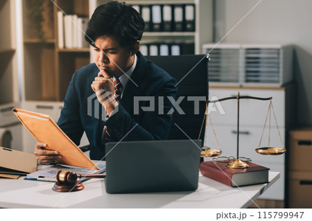 Male lawyer working with contract papers and wooden gavel on tabel in courtroom. justice and law ,attorney, court judge, concept. Male lawyer working with contract papers and wooden gavel on tabel in courtroom. justice and law ,attorney, court judge, concept. 115799947