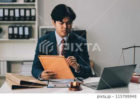 Male lawyer working with contract papers and wooden gavel on tabel in courtroom. justice and law ,attorney, court judge, concept. 115799948
