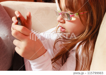 Toddler girl with bandage on eye playing games 115799983
