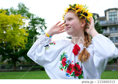 Sunflowers Red-haired girl with a wreath on her head. beautiful girl with a wreath on her head looks at the camera Sunflowers Red-haired girl with a wreath on her head. beautiful girl with a wreath on her head looks at the camera 115800313