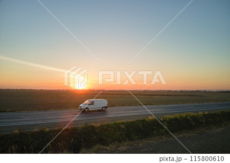 Aerial view of intercity road with blurred fast driving car at sunset. Top view from drone of highway traffic in evening 115800610