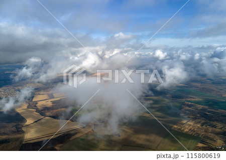 Aerial view from high altitude of earth covered with puffy rainy clouds forming before rainstorm 115800619