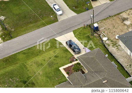 Aerial view of typical contemporary american private house with roof top covered with asphalt shingles and green lawn on yard 115800642
