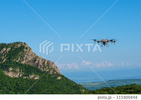 Agricultural drone flying over mountainous landscape 115800848