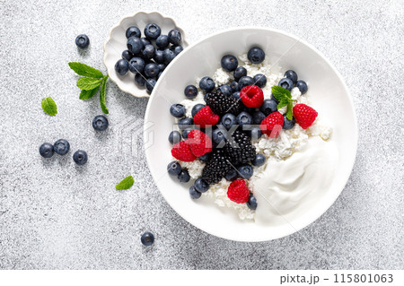 Cheese cottage with yogurt and fresh berries. Curd with blueberry, raspberry and blackberry, top view Cheese cottage with yogurt and fresh berries. Curd with blueberry, raspberry and blackberry, top view 115801063