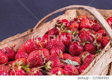 ripe strawberries in a wooden box on the table close up 115804301