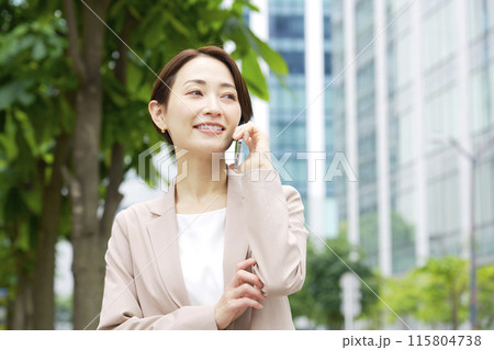 外でスマートフォンで電話をするビジネスウーマン 115804738
