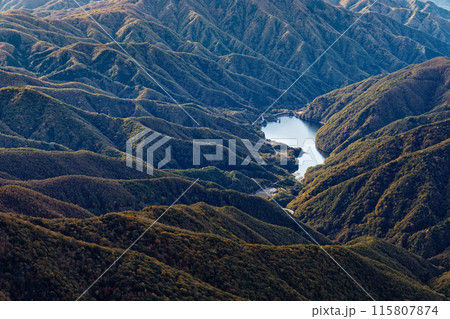 甲武信岳・戸渡尾根から見る紅葉の山並みと広瀬ダム湖 115807874