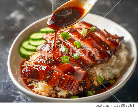Close-up of roast duck topped with sauce on rice. Close-up of roast duck topped with sauce on rice. 115808261