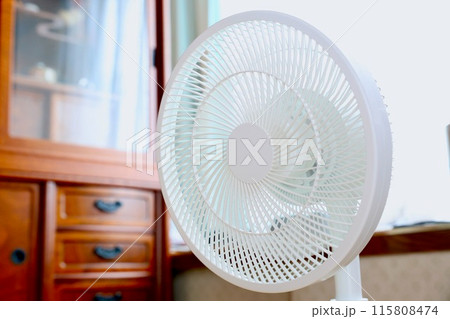 部屋の窓際に置かれた扇風機 115808474