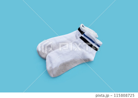 Dirty white socks on blue background. 115808725