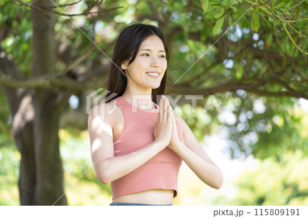 緑豊かな公園でヨガをする女性（屋外ポートレート、合掌、集中、リラックス） 115809191