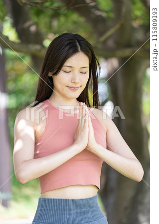 緑豊かな公園でヨガをする女性（屋外ポートレート、合掌、集中、リラックス） 115809193
