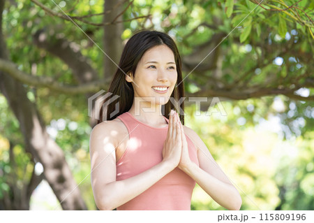 緑豊かな公園でヨガをする女性（屋外ポートレート、合掌、集中、リラックス） 115809196