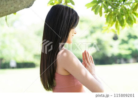 緑豊かな公園でヨガをする女性のボディーパーツ (手を合わせた合掌ポーズ) 緑豊かな公園でヨガをする女性のボディーパーツ (手を合わせた合掌ポーズ) 115809201