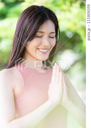 緑豊かな公園でヨガをする女性（屋外ポートレート、合掌、集中、リラックス） 115809209