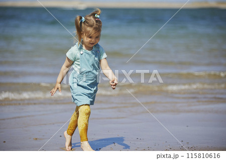Charming child playing on the beach in Denmark Charming child playing on the beach in Denmark 115810616