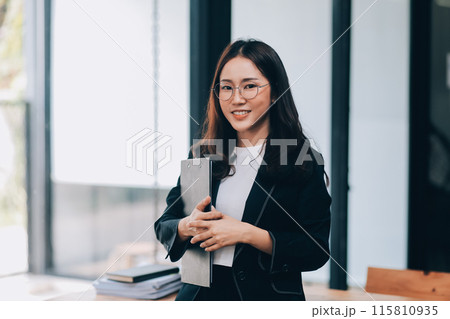 Happy young asian woman, using digital tablet isolated on office background Happy young asian woman, using digital tablet isolated on office background 115810935