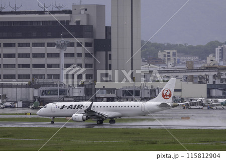 雨の大阪空港・伊丹空港に着陸する旅客機・飛行機・J-AIRエンブライエル190 115812904