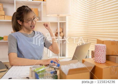 Sell products online, Happy Woman Celebrating Order from Internet Customer: New Business Style, Online Selling, Young Entrepreneur's Success: Work-from-Home SME Owner Thrives in Online Sales. 115814236