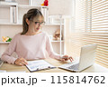 Young woman using a laptop, Work from the comfort of home, Use your laptop for work and communication, Work from home. 115814762